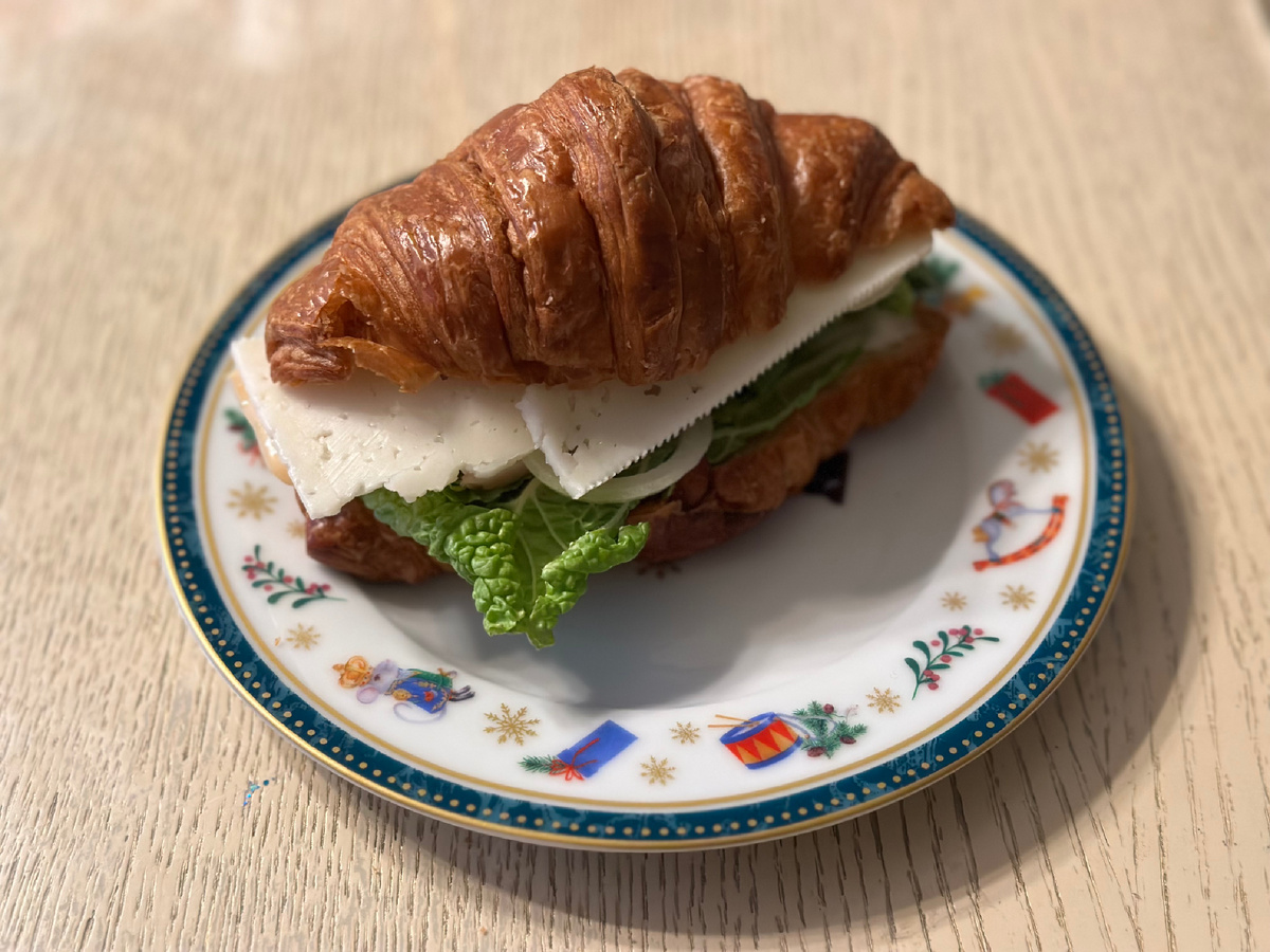 Круассан с ветчиной из индейки, легким сыром, китайской капустой, репчатым луком, огурчиком и соусом 