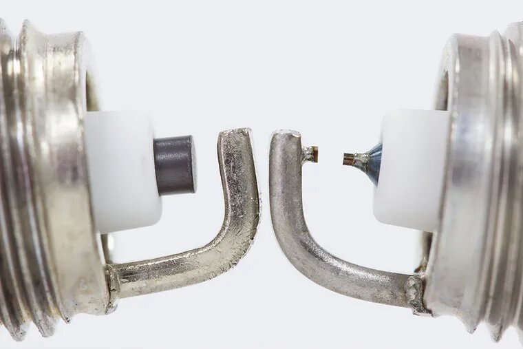 Слева свеча с никелевым центральным электродом, справа — с иридиевым.