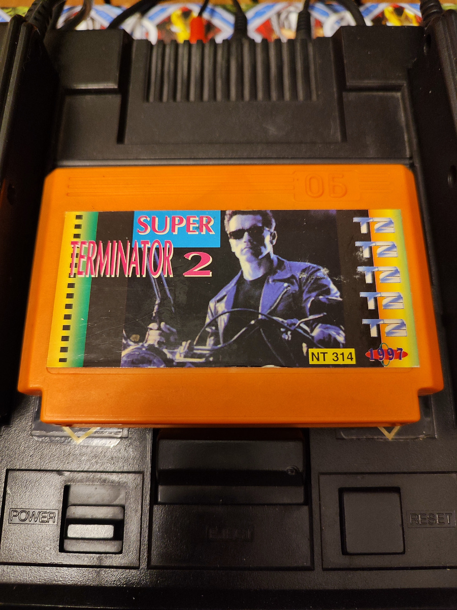 Фото сделаны мной. На фото игра "Terminator 2. Оригинал игры "Terminator 2: Judgment Day" был разработан Arc Developments, Bits Studios, Dementia, Ocean Software, Software Creations и издан Acclaim, LJN, Flying Edge Acclaim Japan, Ocean Software в 1991г. для платформ: Amiga, Amstrad CPC, Atari ST, Commodore 64, DOS, Game Boy, NES, Sega CD, Sega Game Gear, Sega Master System, Sega Mega Drive. Genesis, SNES, ZX Spectrum. Фото демонстрирует начальную заставку игры, а так же общий визуальный фон игры. Подробнее об этом рассказано в статье. Все материалы принадлежат правообладателям и размещены исключительно в информационных целях.