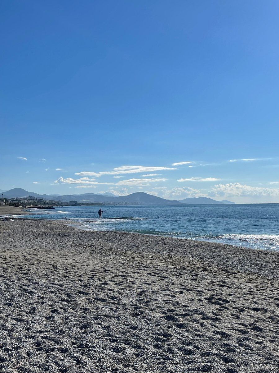 Одинокий рыбак с берега ловит рыбу