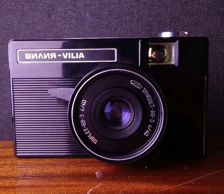Выпускался в 1974—1985 годах Белорусским оптико-механическим объединением. Вторая модель из унифицированного семейства «Вилия». Выпускались четыре модели («Вилия-авто», «Вилия», «Силуэт-электро», «Орион-ЕЕ»), имевшие одинаковый корпус и объектив, отличавшиеся только способом установки экспозиции.  Фотоаппаратов «Вилия-авто» и «Вилия» выпущено около 3 млн экз. Технические характеристики: Тип — шкальный малоформатный фотоаппарат.Тип применяемого фотоматериала — плёнка типа 135 в стандартных кассетах. Размер кадра — 24×36 мм. Корпус — пластмассовый, с откидной задней пластмассовой крышкой. На крышке находится шкала-памятка светочувствительности заряженной фотоплёнки. Курковый взвод затвора и перемотка плёнки. Приёмная катушка несъёмная. Счётчик кадров самосбрасывающийся при открывании задней крышки. Объектив — Триплет «Т-69-3» 4/40, несъёмный. Резьба для крепления светофильтров — М46×0,75 мм. Диафрагма четырёхлепестковая залинзовая (за центральным затвором). Наводка на резкость по шкале символов и расстояний.  Видоискатель оптический телескопический с увеличением 0,6×, с подсвеченными кадроограничительными рамками (внутренняя — для коррекции параллакса при съёмке с расстояния менее 3 метров).  Фотографический затвор — центральный залинзовый, двухлепестковый, значения выдержек от 1/30 до 1/250 с и «В». Значение диафрагм от f/4 до f/16.  Фотоаппарат «Вилия» имеет ручную установку экспозиции: выдержка устанавливается применительно к значению светочувствительности фотоплёнки, а диафрагма по символам погоды, в поле зрения видоискателя отображаются пиктограммы («ясно», «солнце в дымке», «облачно», «пасмурно», «грозовые тучи»), с нужной необходимо совместить подвижный указатель. Синхроконтакт и центральный синхроконтакт «X», обойма для крепления фотовспышки. Выдержка синхронизации — любая.  Резьба штативного гнезда 1/4 дюйма. Резьба под спусковой тросик отсутствует.