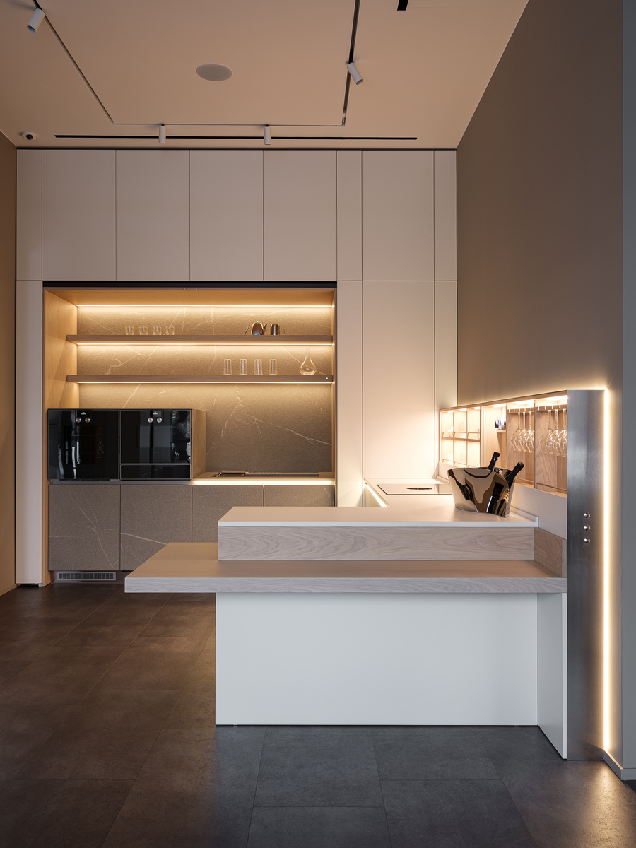 Пристенная часть с зоной мойки оснащена новым механизмом задвижных дверей с электротолкателями. Он позволяет одновременно открывать и закрывать две соединенные между собой двери, обеспечивая доступ в к шкафам и открытым полкам в нише шириной 2400мм. Система магнитного контроля и стабилизации движения обеспечивает максимально плавное движение.