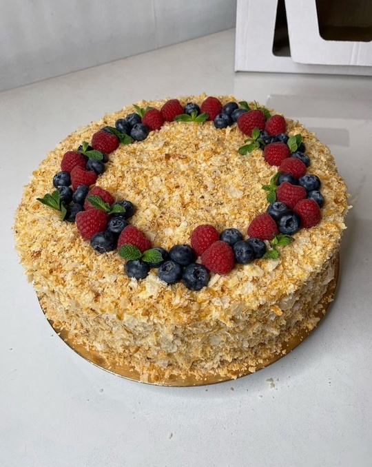 На фото классический торт "Наполеон" собственного изготовления украшен ягодами голубики, малины и листочками мяты. Семейная кондитерская "Bourbon Shop".