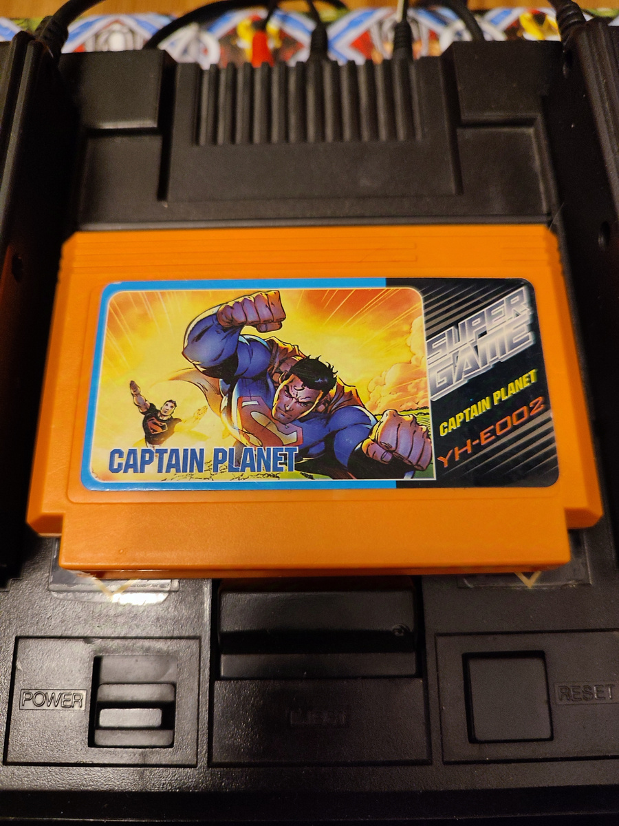 Фото сделаны мной. На фото игра Игра "Капитан Планета". Оригинал игры "Captain Planet and the Planeteers" был разработан Chris Gray Enterprises, издан Mindscape в 1992,.г. для  NES и Sega Mega Drive и других платформ. Персонажи созданы Тедом Тернером, Барбарой Пайл. Фото демонстрирует начальную заставку игры, а так же общий визуальный фон игры. Подробнее об этом рассказано в статье. Все материалы принадлежат правообладателям и размещены исключительно в информационных целях.