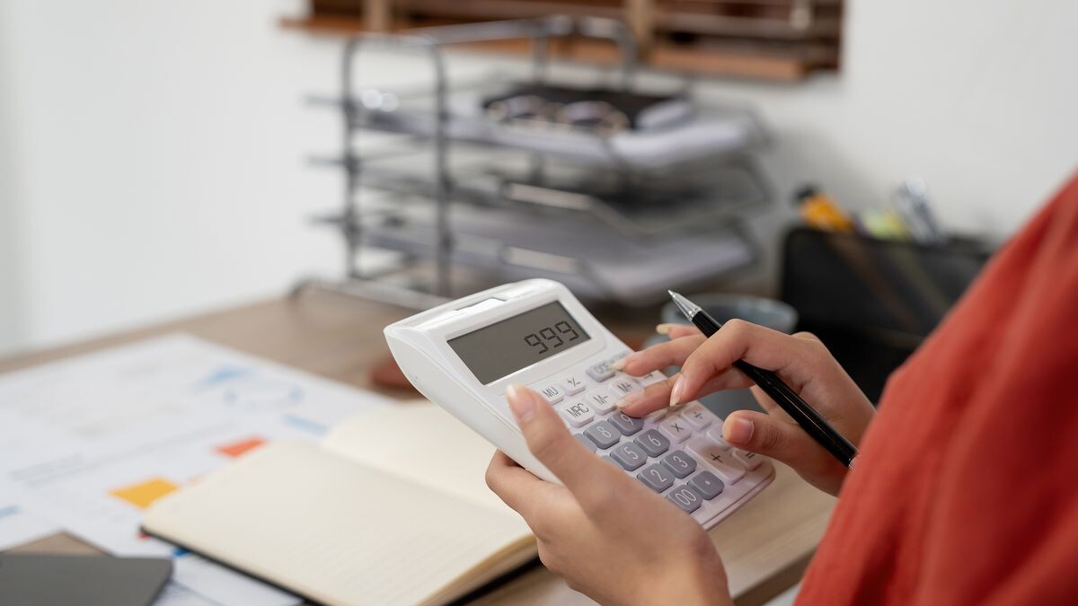 Изображение: Человек, планирующий бюджет с калькулятором и блокнотом. Описание: Планирование бюджета — первый шаг к финансовой стабильности.