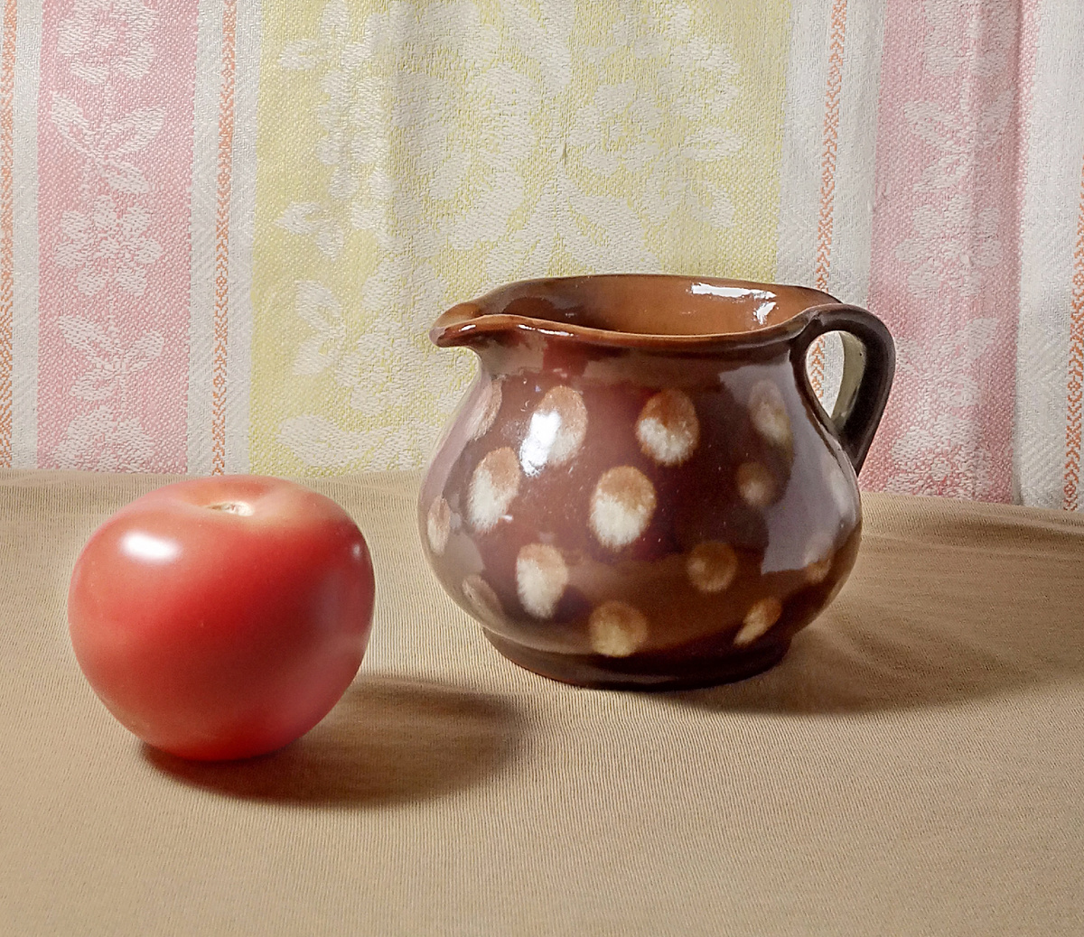 В этом натюрморте оба предмета темнее, чем фон. Самая светлая часть натюрморта - ткань на вертикальной плоскости за предметами, чуть темнее ткань на столе. Помидор  светлее, чем кувшин. Фотография автора канала 