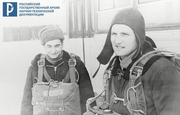 Космонавты В.Ф. Быковский и Б.В. Волынов во время парашютной подготовки у автобуса на поле аэродрома. 1964 г. РГАНТД. Арх. № 1-11251