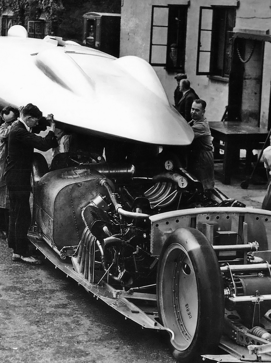 вид сзади на рекордный автомобиль Railton Special вскоре после завершения его изготовления в 1938 году. После того как цельный кузов был снят, все внутренние узлы автомобиля становились доступными. Большой бак для воды находится слева, а перед задними колесами виден тормозной щиток виден перед задними шинами
