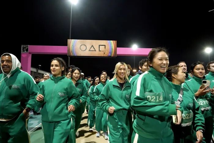    Фанаты в тренировочных костюмах из «Игры в кальмара» участвуют в забеге на 4,56 км в Лос-Анджелесе.