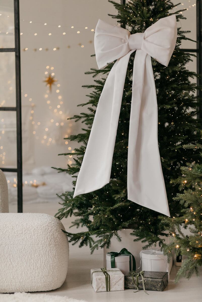 Вариант эффектного украшения елки белым бантом. studio456.ru