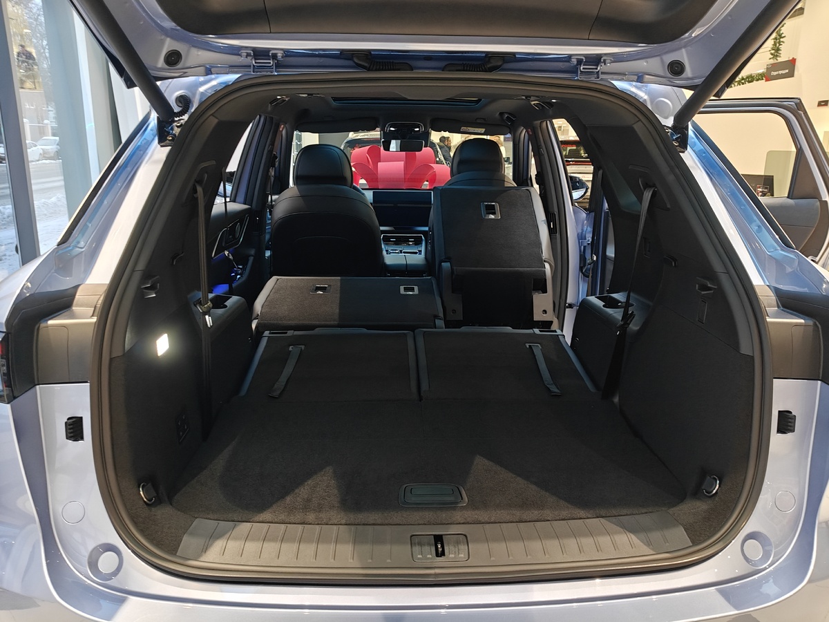 Третий ряд складывается вручную, в помощь лямки ремней и ручки вверху по внешним краям торцов спинок. Спинки второго ряда складываются/раскладываются электрически посредством блока кнопок в багажнике слева. Для каждой части по две кнопки на каждое действие. Откидывание и возврат правой части второго ряда через две кнопки в торце ее спинки. При активации так же уезжает вперед и складывает спинку пассажирское кресло.