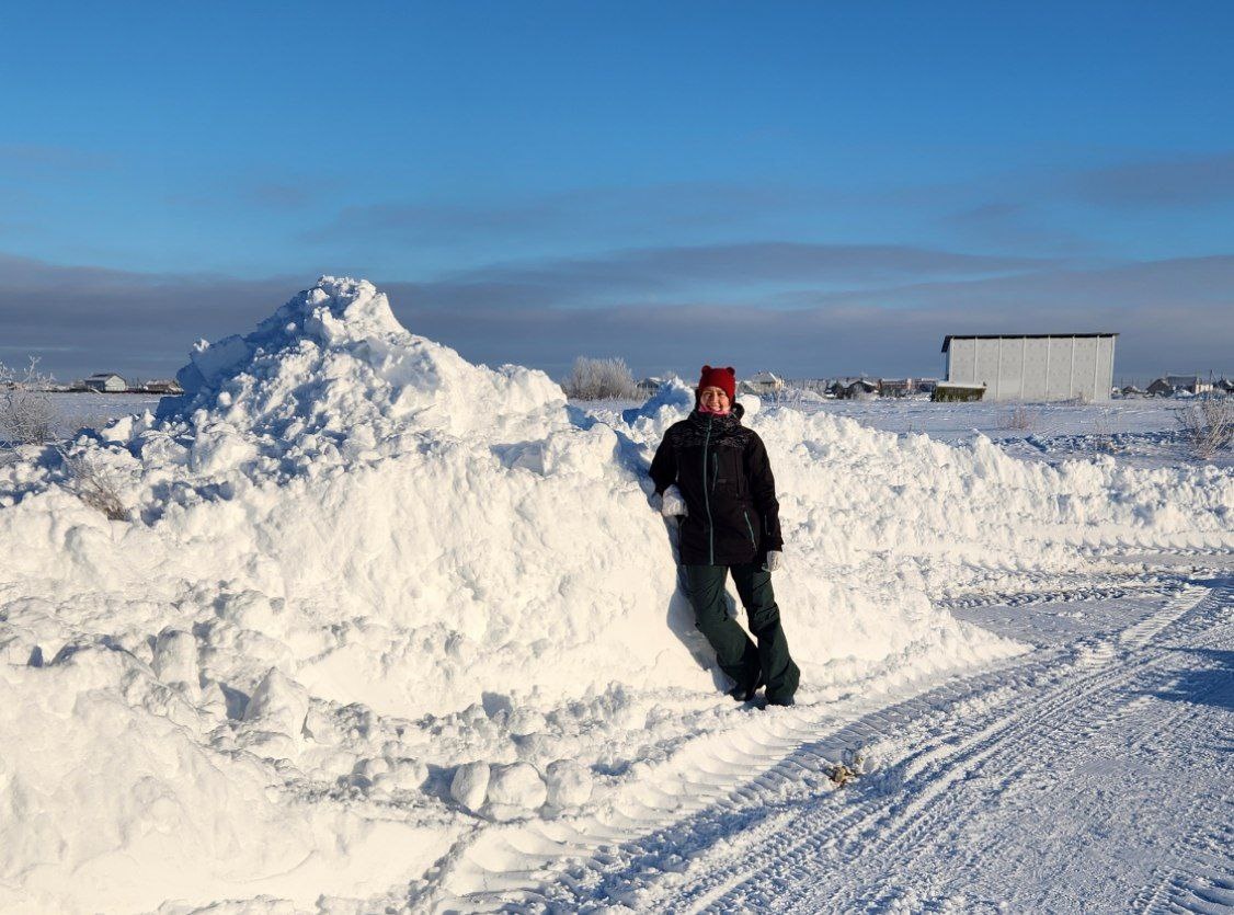 Высота сугроба выше человека. После уборки трактором