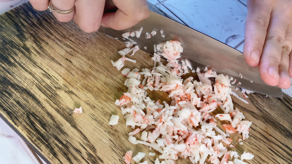 Измельчите крабовые палочки удобным способом