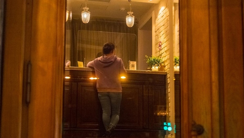    Женщина стоит и оформляет проживание на стойке гостиницы в центре Петербурга. Автор фото: Тихонов Михаил