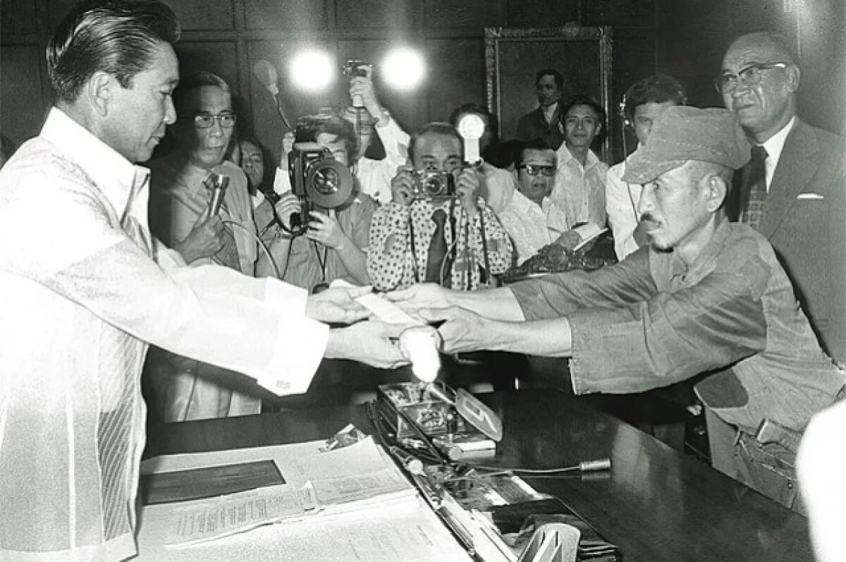    Онода вручает свой меч президенту Филиппин Фердинанду Маркосу на церемонии 11 марта 1974 года.