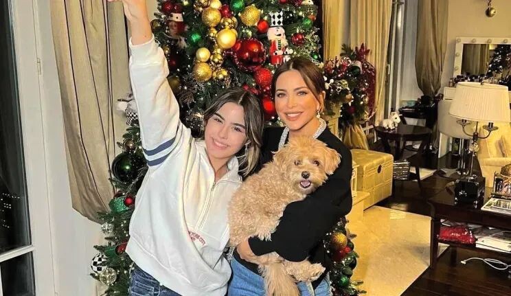 Мама и дочка вместе наряжают елочку