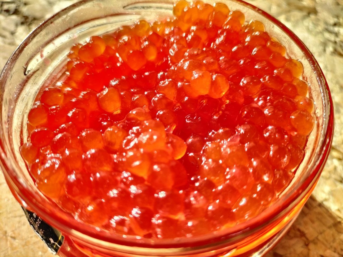 Икринки абсолютно одинаковые. Натуральная красная икра разная по размеру. Также в банке было пустое место.