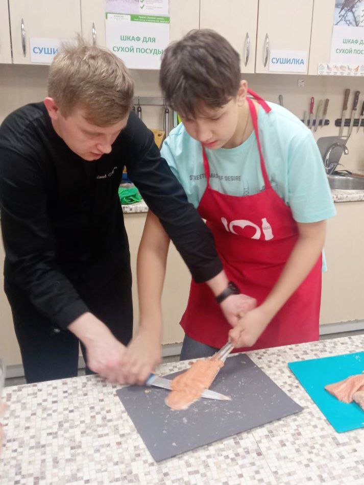 Шеф-повар ресторана учит Николя разделывать рыбу.