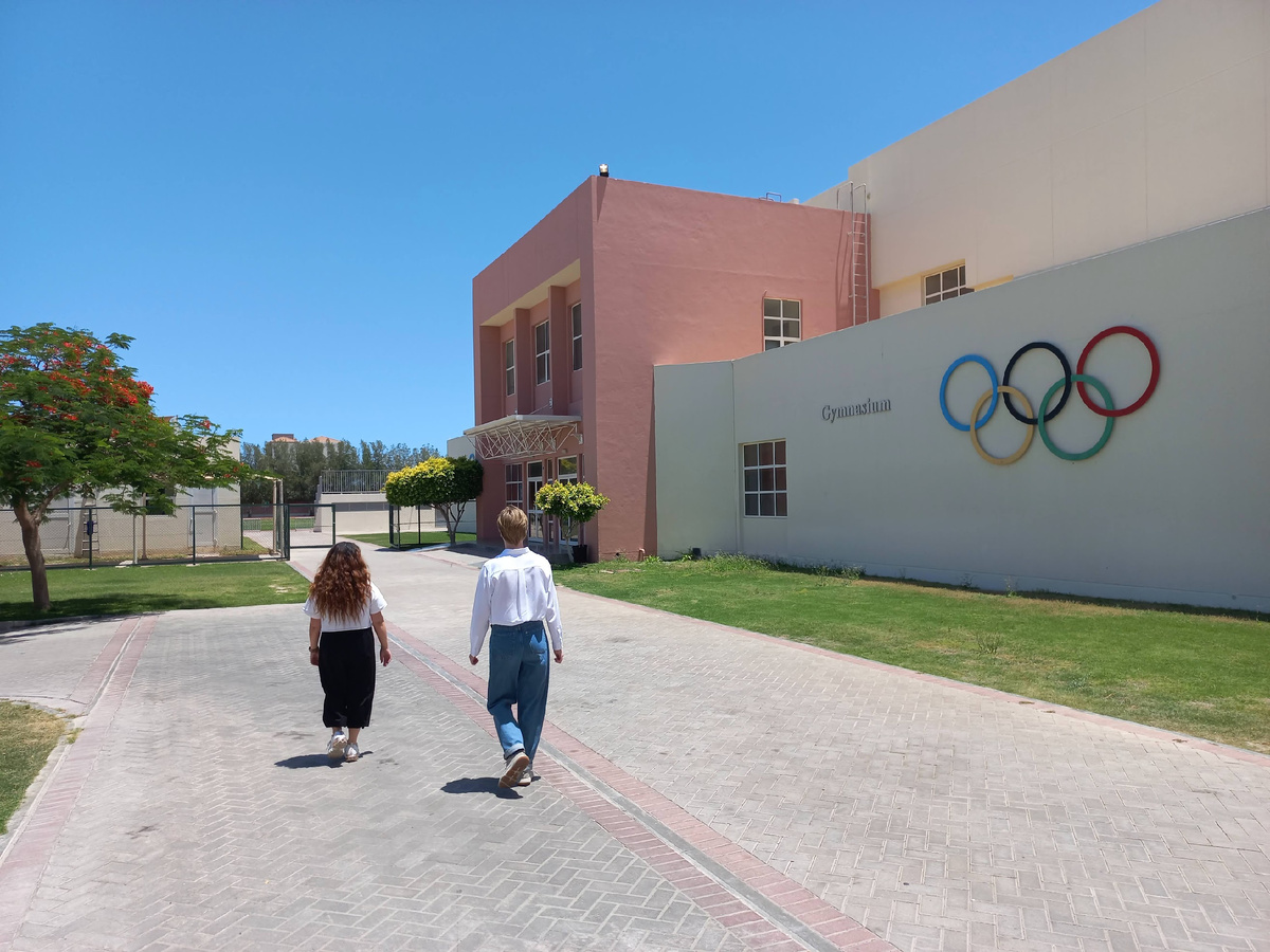 Нашего маленкого ребенка ведут показывать спортзал школы Сабис