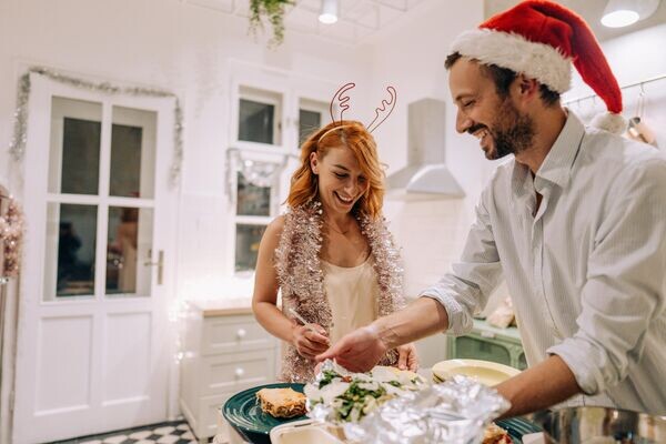 Семья готовит новогодний ужин. © iStock.com / AleksandarNakic