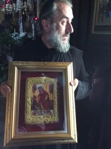 Архимандрит Поликарп держит икону Богородицы, украшенную пчелами. Фото из свободного источника в Интернете.