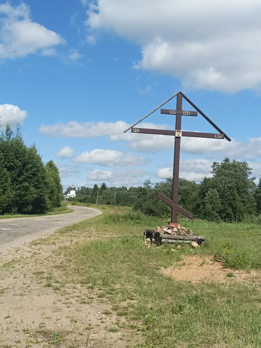 Тут же у шоссе поклонный крест. На заднем фоне видна Покровская церковь