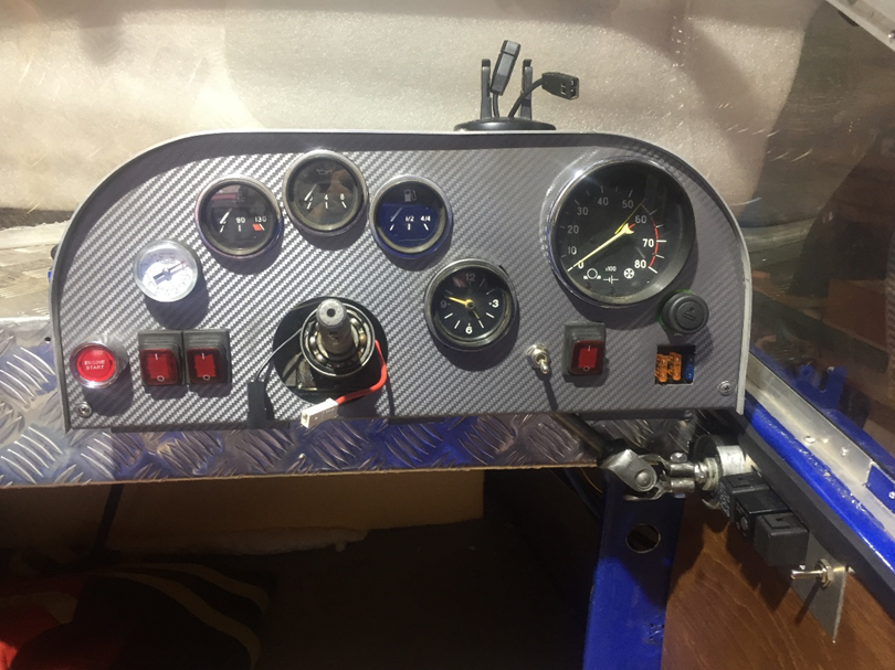 Приборы: манометр, указатель температуры ДВ, указатель давления масла в ДВ, указатель уровня топлива, часы, тахометр, прикуриватель и блок предохранителей. Кнопки: кнопка пуск-старт, выключатель помпы, выключатель топовых огней, тумблер - подогрев руля, выключатель зажигания.