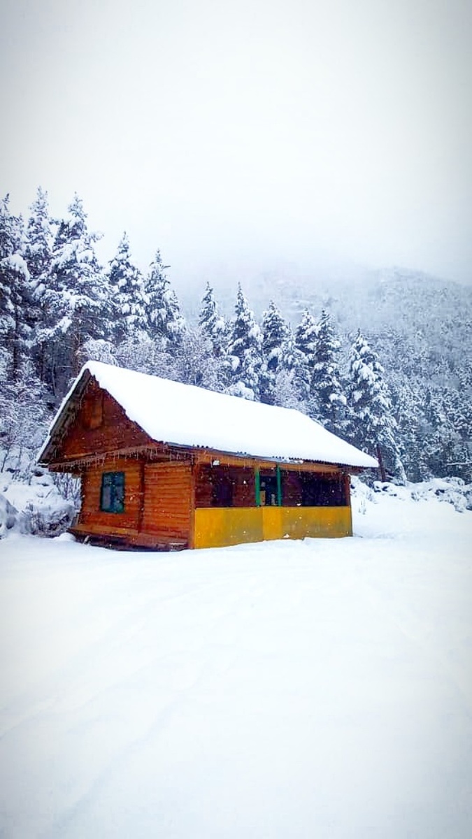 Домик у реки у подножия горы 