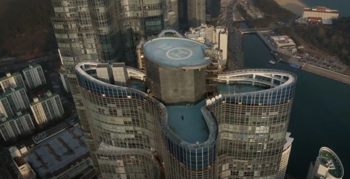 Начнем с вертолётной площадки, куда Ким Хи У пришёл умирать. У меня сначала закралось подозрение, что это наложенный на хромакей вид, но оказалось нет. Сцену снимали на крыше самого высокого здания жилого комплекса Haeundae Doosan We've The Zenith в Пусане. 80-й этаж.