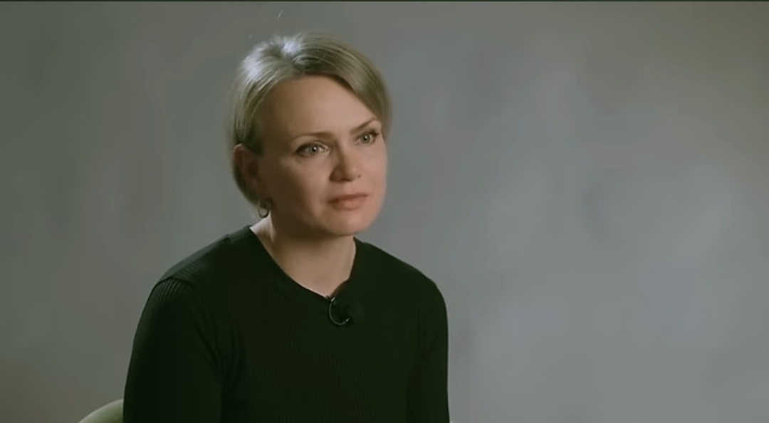 Скриншот из видео. Мария. А её муж Анатолий общественный деятель. Создал фонд «Путь домой». И помогает русским людям возвратиться на Родину в Россию.