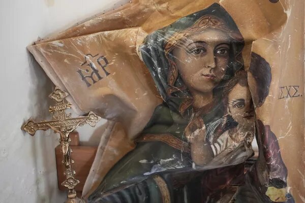 Поврежденная икона и крест © AP Photo / Hassan Ammar 