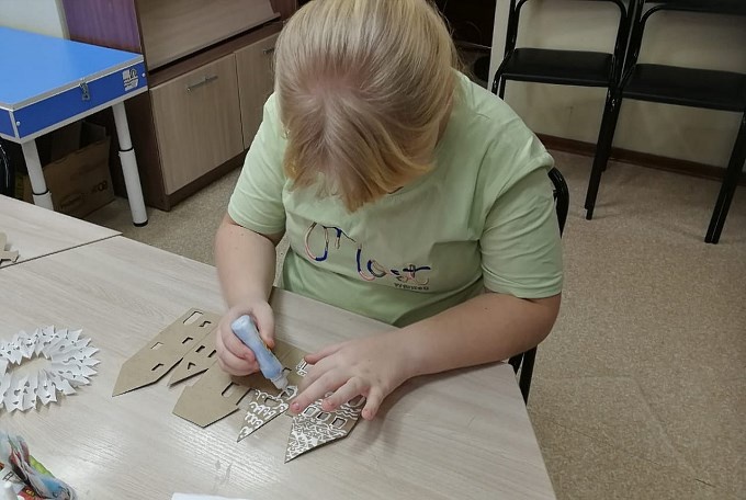 Девочка раскрашивает картонный домик