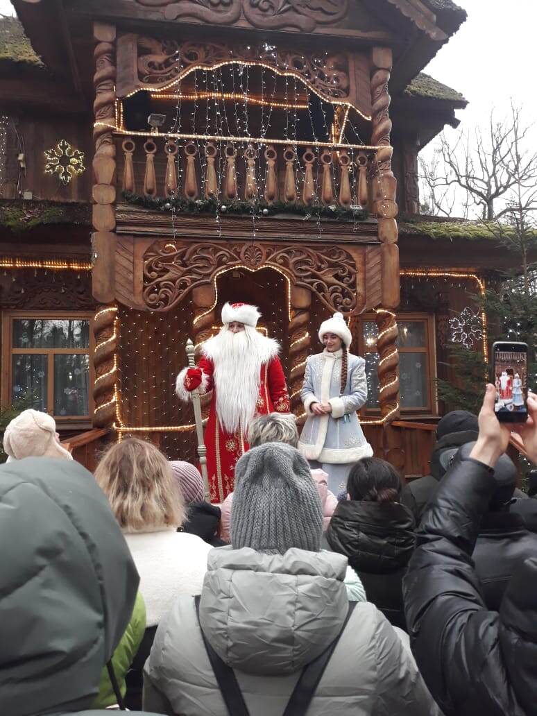 Дед Мороз со Снегурочкой на пороге своего терема.