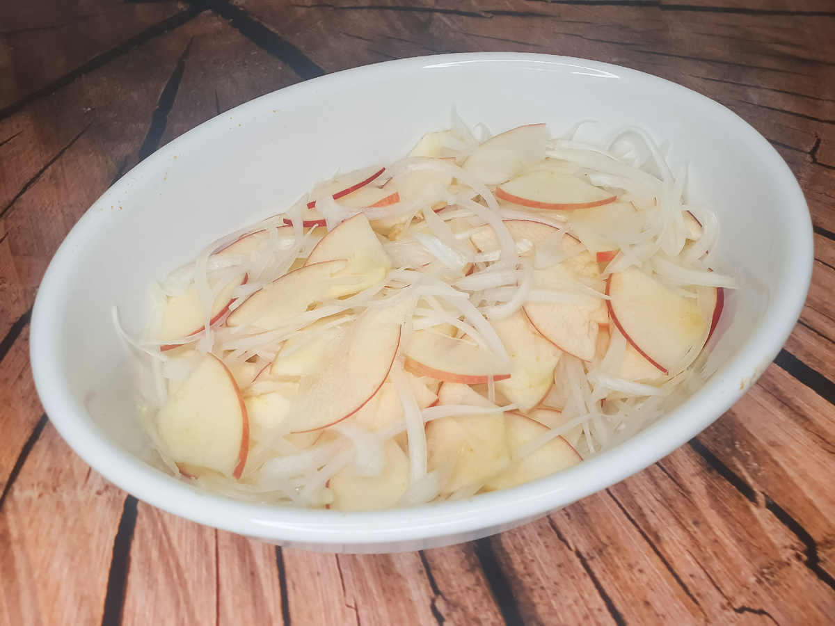 Выкладываем половину лука и яблок