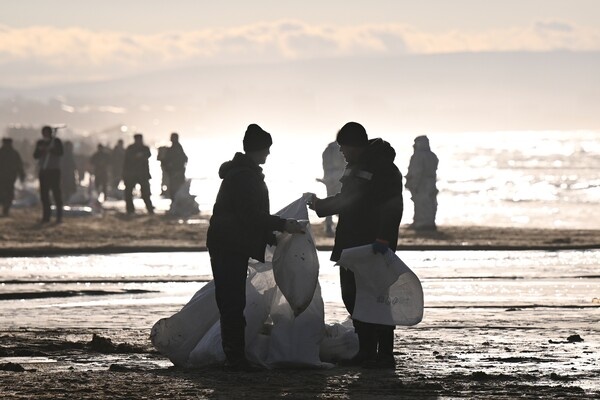 Волонтеры собирают мазут на берегу Анапы после крушения двух танкеров, 21 декабря 2024 года / Алексей Майшев/РИА Новости   📷