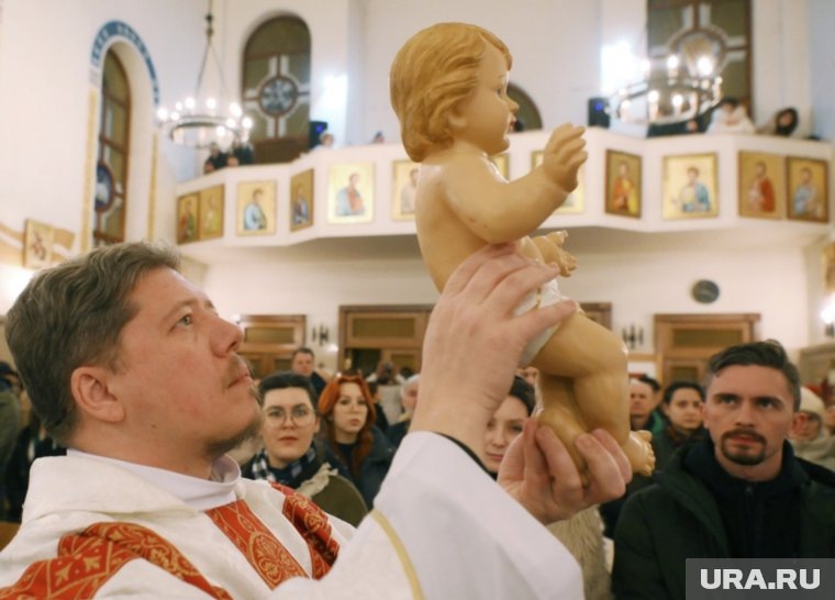 Рождественское богослужение в римско-католическом храме Воздвижения Святого Креста в Казани, настоятель храма отец Андрей держит на руках фигуру Иисуса Христа
Фото:Максим Богодвид/РИА Новости