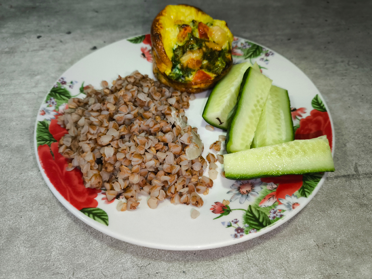 Тифлокомментарий. Фото моего завтрака: гречка, яичный маффин и свежий огурец.