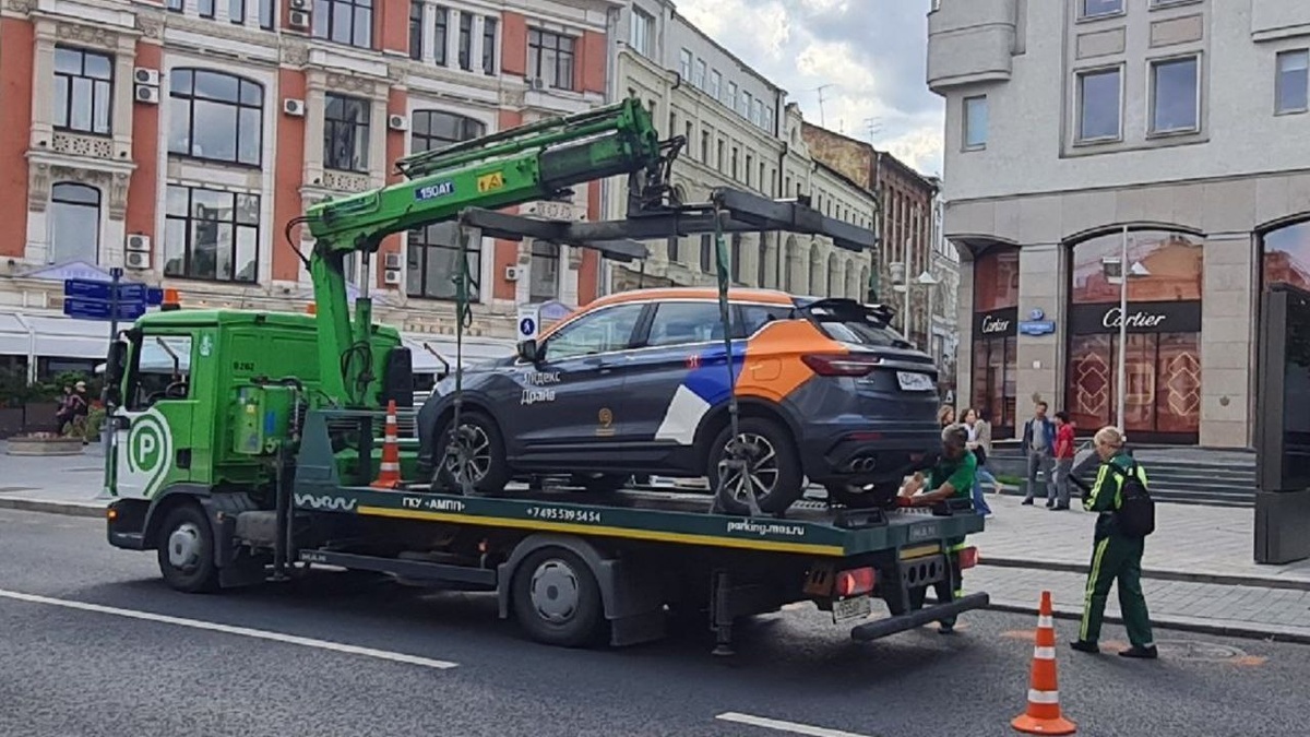 Автомобиль "Яндекс Драйв" забирают за парковку на месте для инвалида сотрудники ЦОДД.