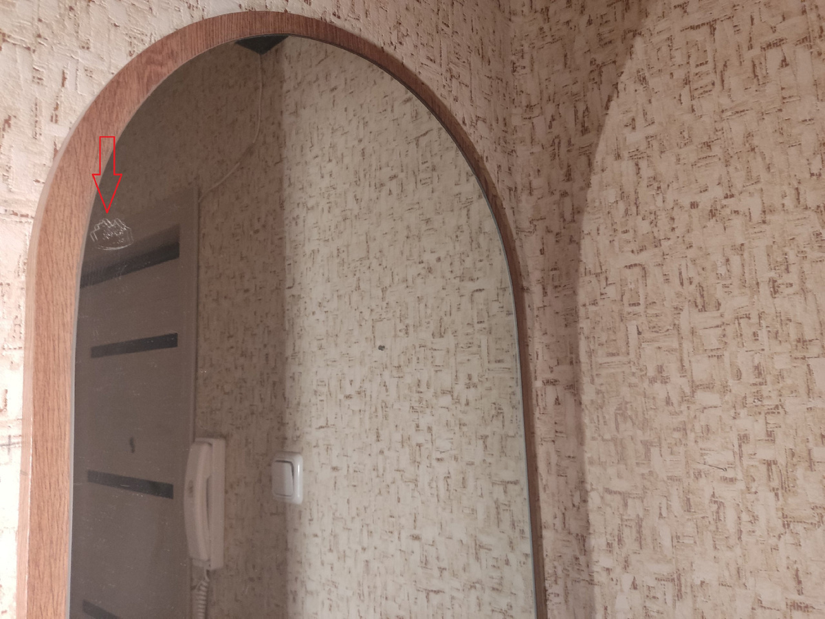 До: следы скотча на зеркале отмечены стрелкой