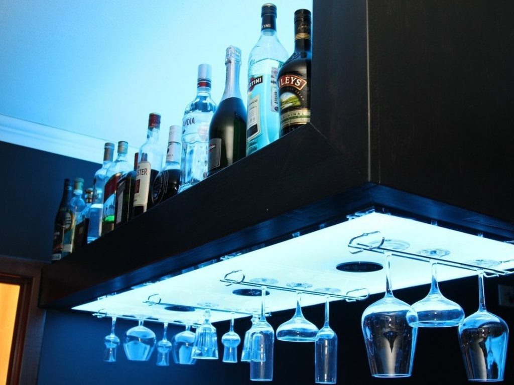 Можно разместить полку, которая будет вмещать и бутылки, и бокалы