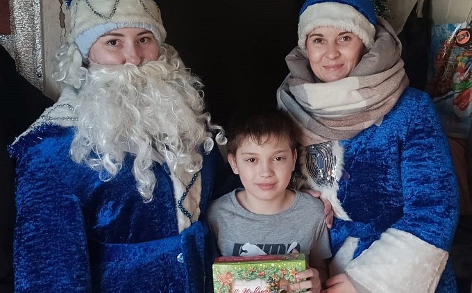 Мальчик получил подарок от Деда Мороза и Снегурочки