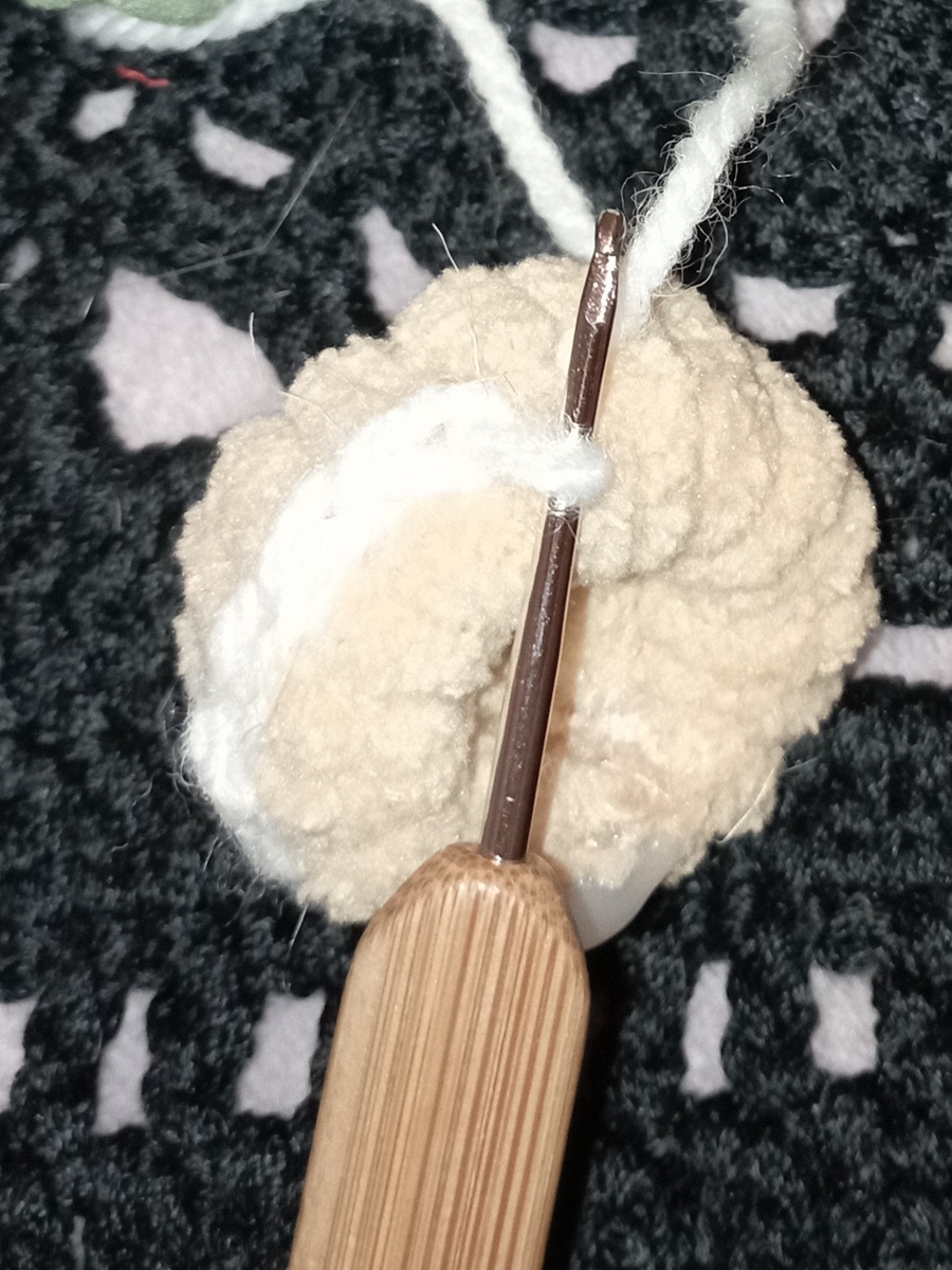 Обвязываю деталь бисквита кекса. Набираю петли посередине бисквита и вяжу пышным узором имитацию взбитых сливок. 