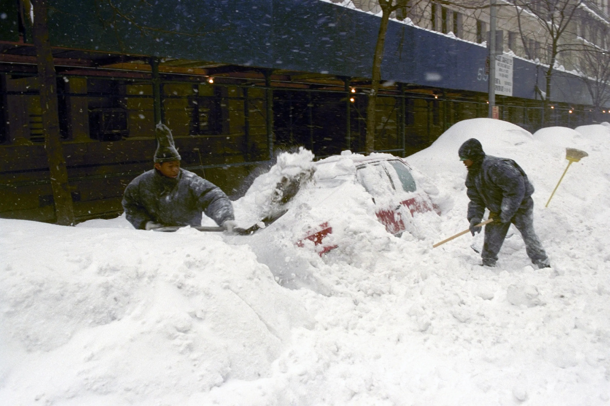 Подростки зарабатывают деньги, расчищая снег с машин на Амстердам-авеню в Манхэттене.