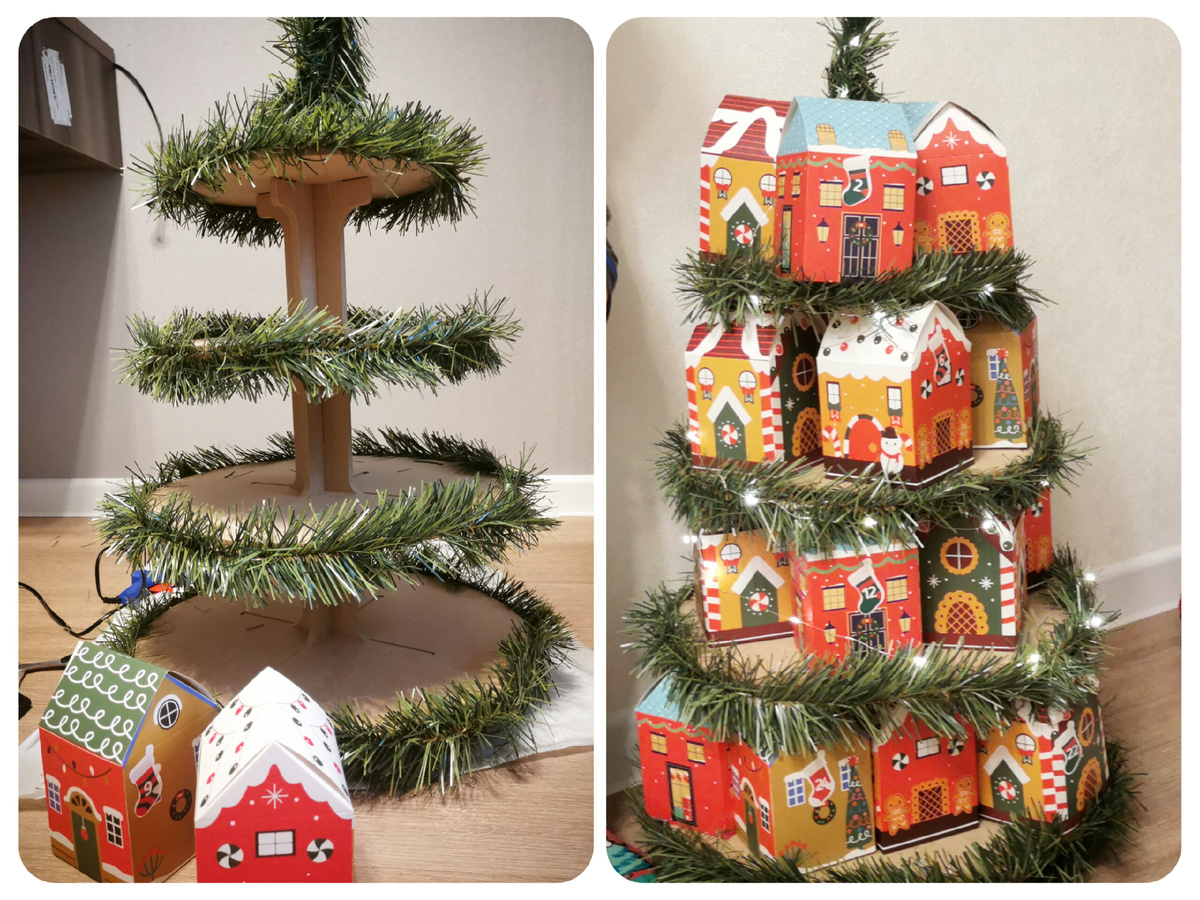 Вот такое сооружение у меня получилось. Полки по периметру обклеила хвойной мишурой, а в конце добавила светодиодную гирлянду. Здесь 24 домика
