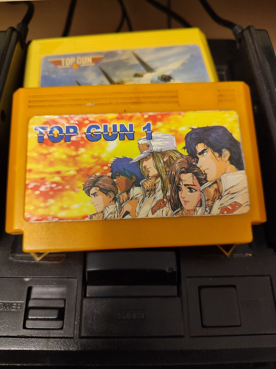 Фото сделаны мной. На фото игра "Top Gun". Оригинал игры "Top Gun" был разработан и издан  Konami в 1987,.г. для приставки NES. Дизайнеры Бонобо Норико, Китт Бунко, Куджакусума Акеми, Некоманма Ику, Амадеус Митчи. Фото демонстрирует начальную заставку игры, а так же общий визуальный фон игры. Подробнее об этом рассказано в статье. Все материалы принадлежат правообладателям и размещены исключительно в информационных целях.