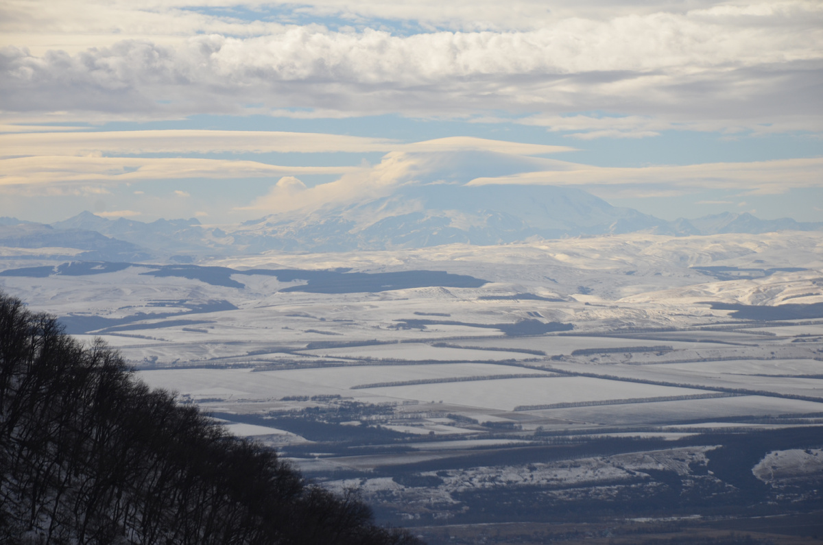 "Как айсберг в небе в облаках, Плывёт двуглавая вершина". Вид Эльбруса и цепи гор.