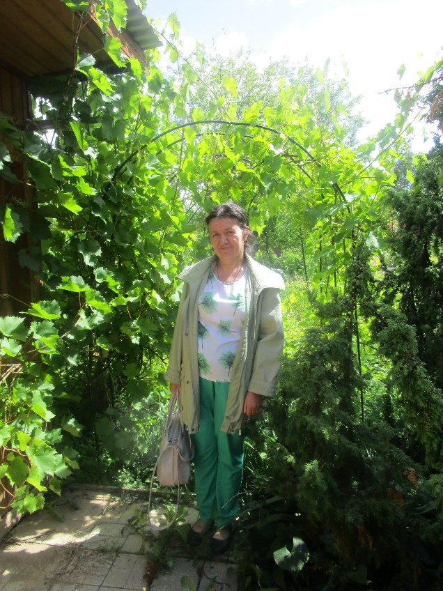 Я на даче у сестры, около виноградных веток стою. Виноград у сестры хороший, мне нравится