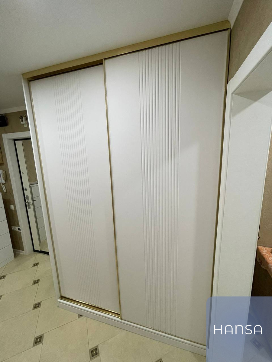 Белый шкаф-купе, выполненный с фрезерованными фасадами на заказ фирмой Hansa Mebel