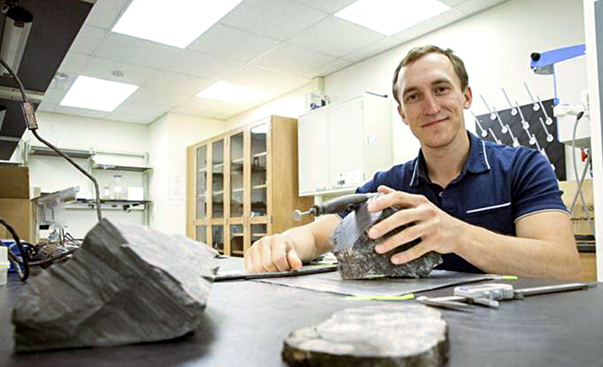 На фото семилетней давности палеоэколог колледжа Густава Адольфа Эрик Гулбрансон изучает окаменелости Антарктики. 