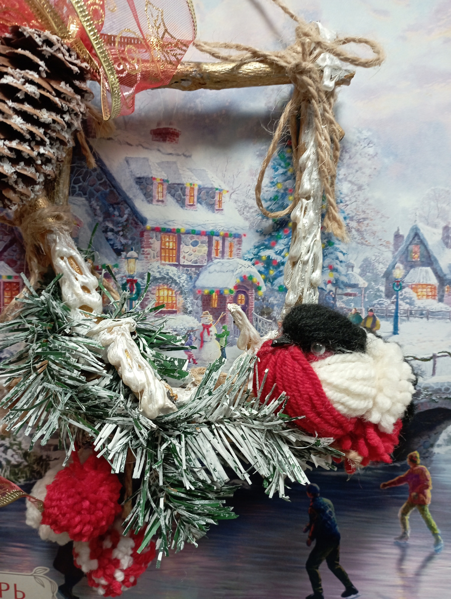 Снегирь из ниток на фоне постера картины художника Томаса Кинкайда